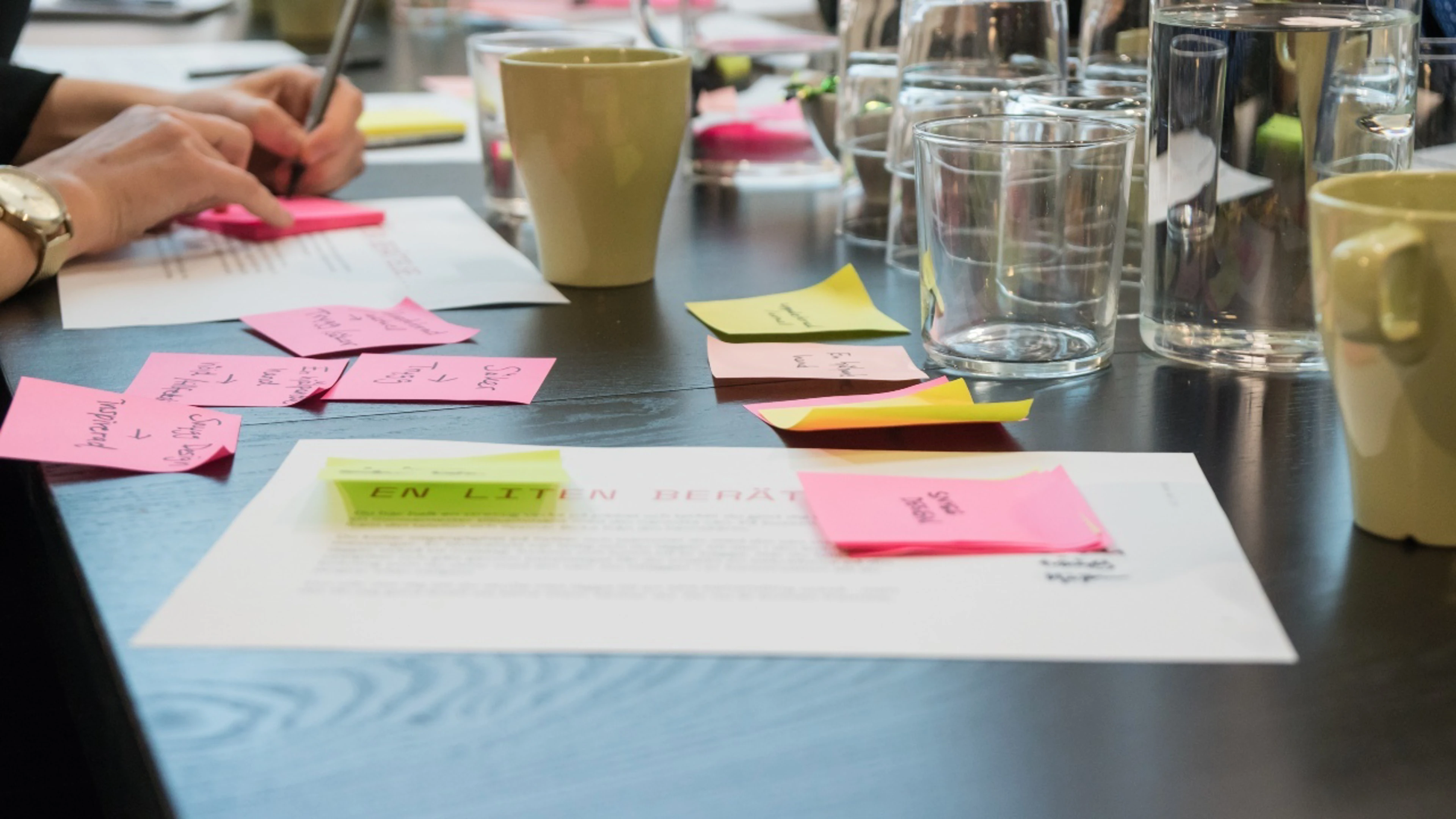 Flera post it-lappar med text på ett bord